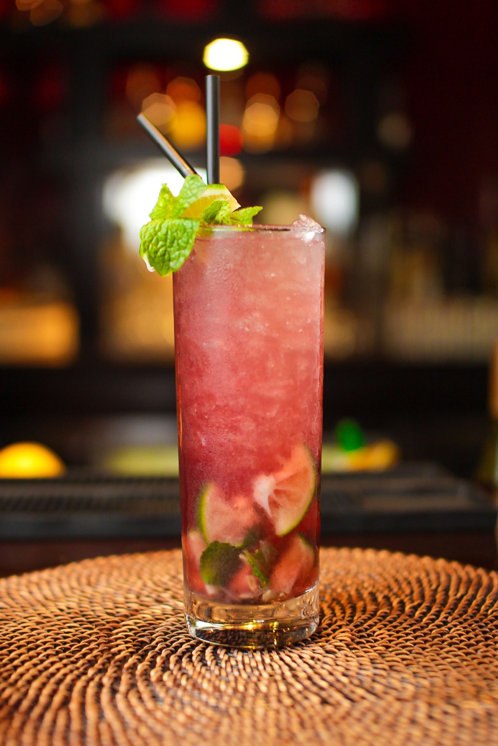 Vertical closeup of a refreshing citrusy cocktail on a bar counter